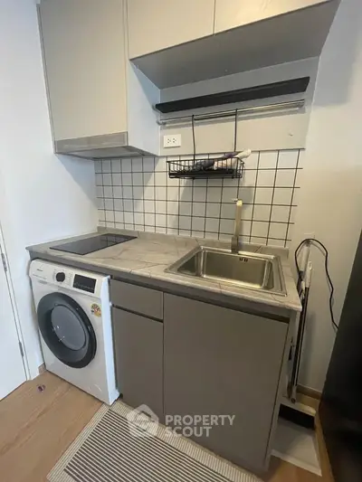 Compact modern kitchen with washing machine and sleek cabinetry
