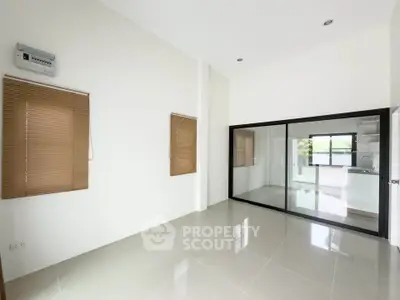 Spacious modern interior with sleek glass partition and tiled flooring, ideal for contemporary living.