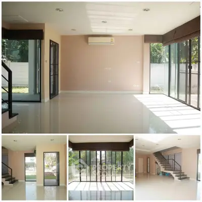 Spacious living room with large windows and modern staircase, perfect for natural light lovers.