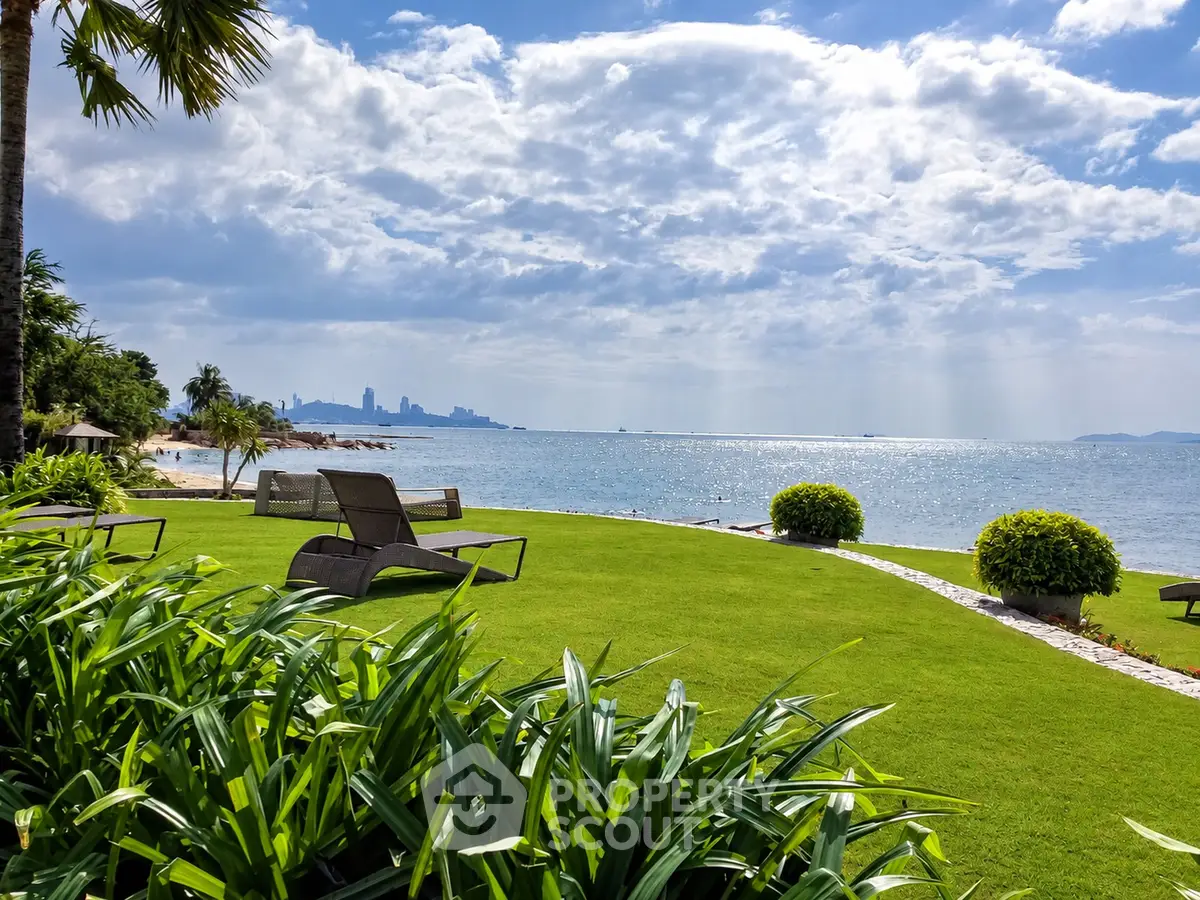 Stunning beachfront property with lush green lawn and ocean view, perfect for relaxation and luxury living.