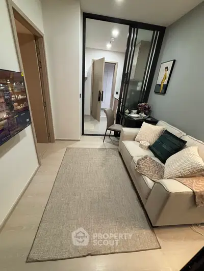 Cozy modern living room with stylish decor and comfortable seating in a compact apartment.