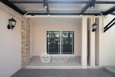 Charming covered patio with sliding glass doors and elegant lighting fixtures.