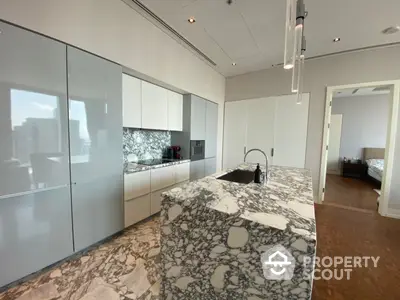 Sleek modern kitchen with marble countertops and integrated appliances, offering a seamless design that blends functionality with style, perfect for culinary enthusiasts.