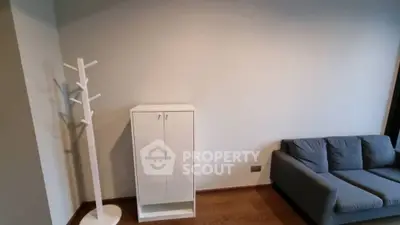 Minimalist living room with gray sofa and white cabinet on wooden floor