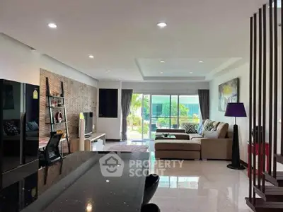Spacious modern living room with elegant decor and large windows offering garden views.