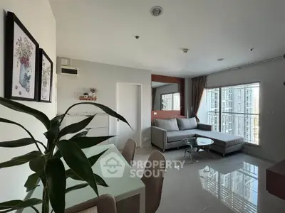 Modern living room with large windows and stylish furniture in a high-rise apartment.