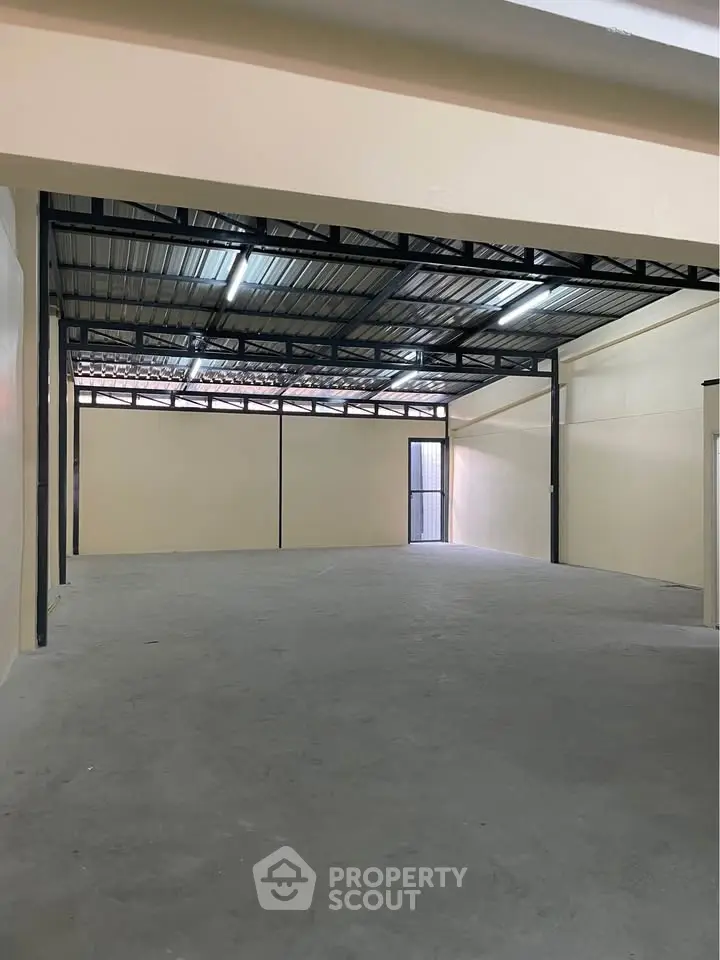 Spacious industrial warehouse with high ceilings and ample natural light, perfect for storage or business operations.