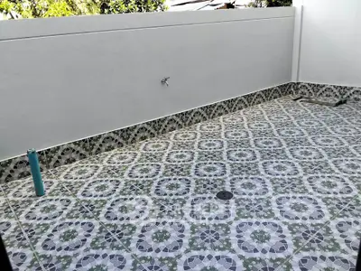 Spacious tiled outdoor area with decorative patterns and privacy wall