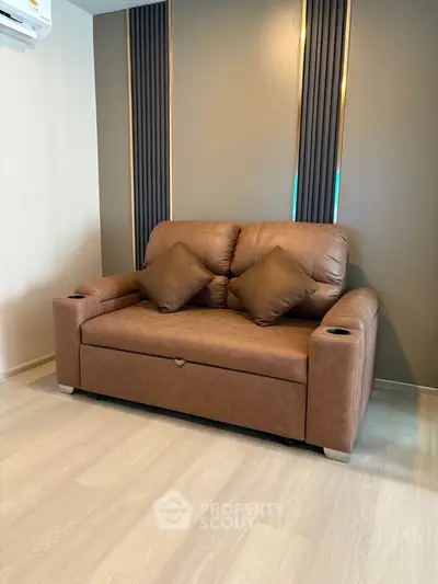 Modern living room with stylish brown leather sofa and elegant wall paneling.