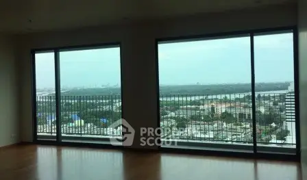 Spacious living room with floor-to-ceiling windows offering stunning cityscape views.
