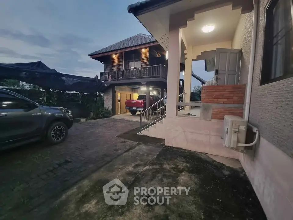 Charming two-story home with spacious driveway and covered parking area at dusk.