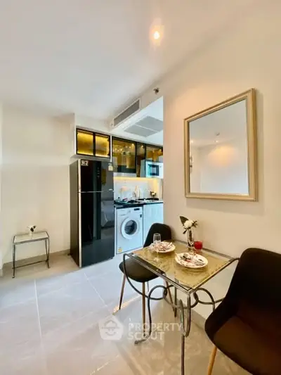 Modern kitchen with dining area and washing machine, sleek design and bright lighting.