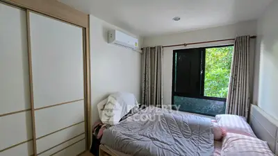 Cozy bedroom with large window and modern air conditioning unit