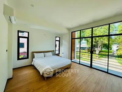 Spacious bedroom with large windows and scenic garden view