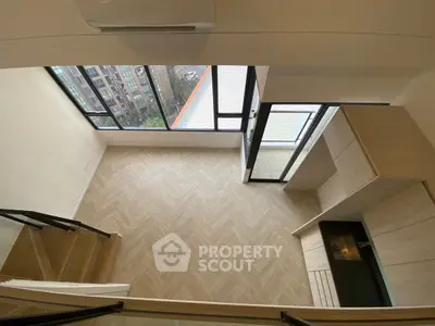 Modern loft apartment with large windows and stylish wooden flooring.