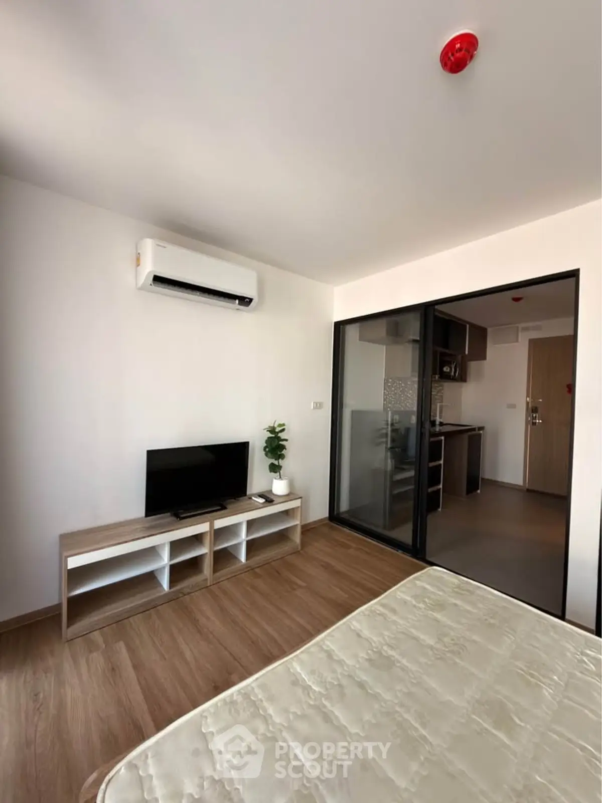 Modern studio apartment with open layout, featuring a cozy living area and sleek kitchen design.