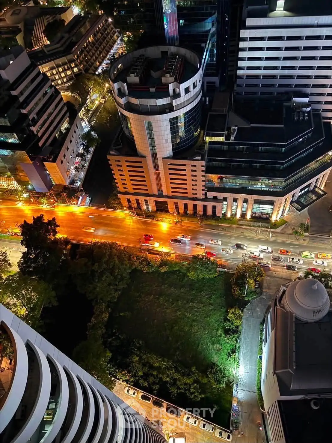 Stunning aerial view of modern cityscape with illuminated streets and high-rise buildings at night.