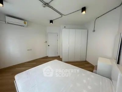 Spacious minimalist bedroom with modern lighting and air conditioning