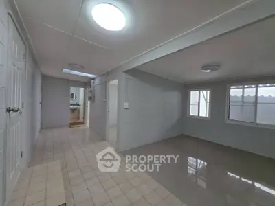 Spacious interior with tiled floors and ample natural light, ideal for versatile living arrangements.