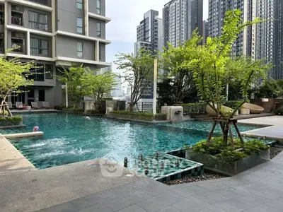Luxurious condominium pool area with modern design and lush greenery.
