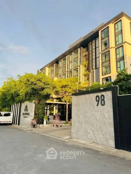 Modern apartment building with lush greenery and clear blue sky