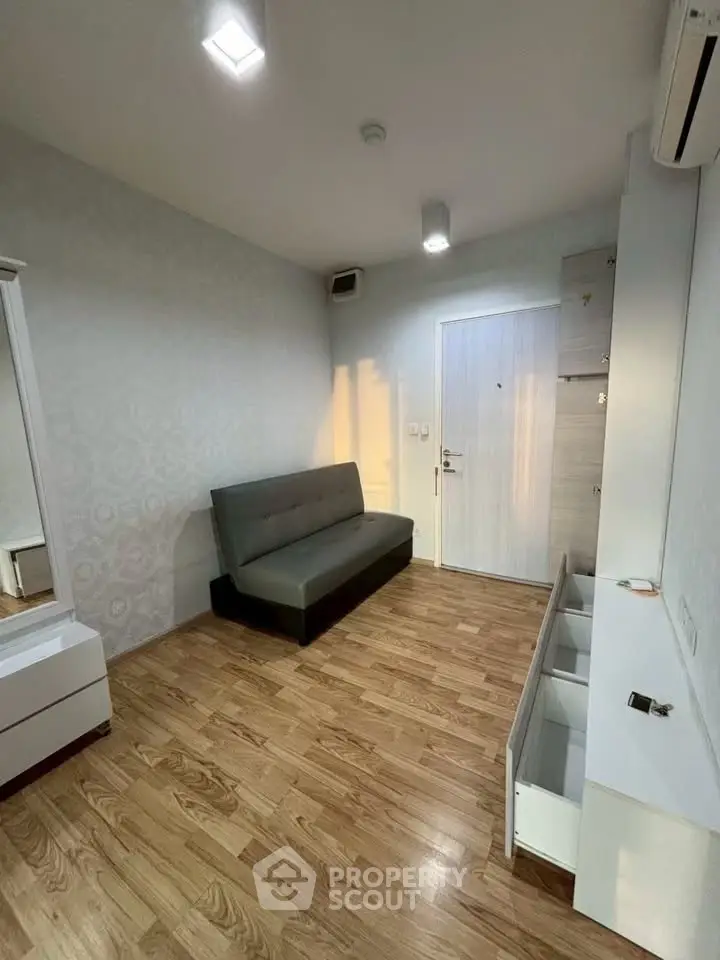 Modern living room with wooden flooring and minimalist furniture in a cozy apartment.