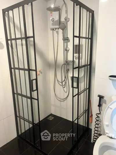 Modern bathroom with sleek black-framed shower enclosure and contemporary fixtures.
