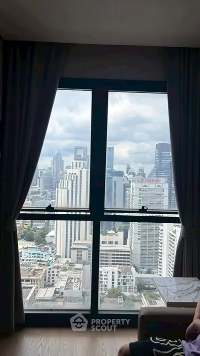 Stunning cityscape view from a high-rise apartment window, showcasing urban skyline and modern architecture.