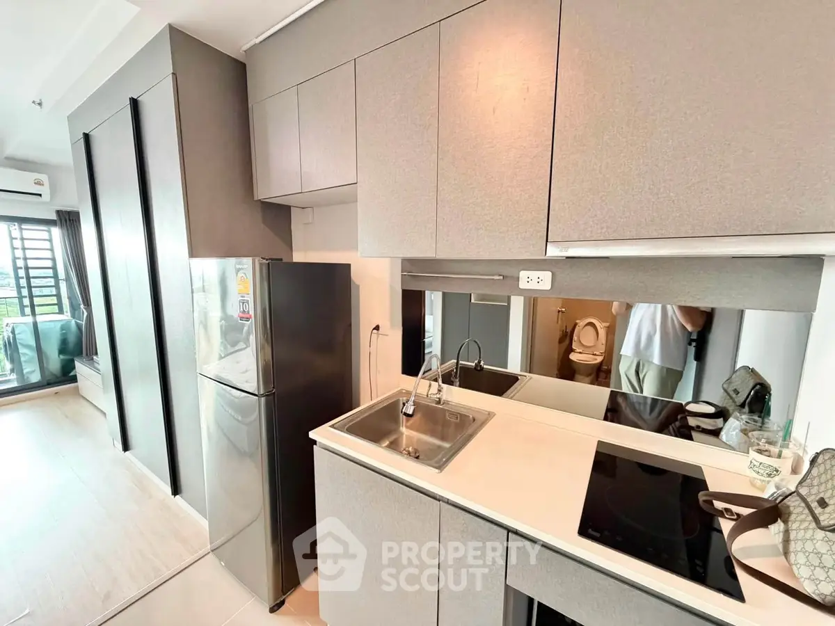 Modern kitchen with sleek cabinetry and stainless steel appliances in a stylish apartment.