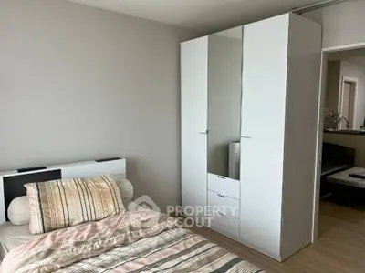 Cozy bedroom with modern white wardrobe and stylish bedding in a well-lit space.