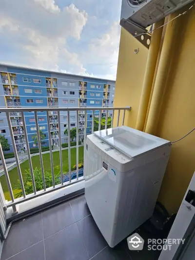 Charming balcony with washing machine and scenic view of residential building