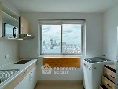 Modern kitchen with city view, featuring sleek appliances and ample natural light.