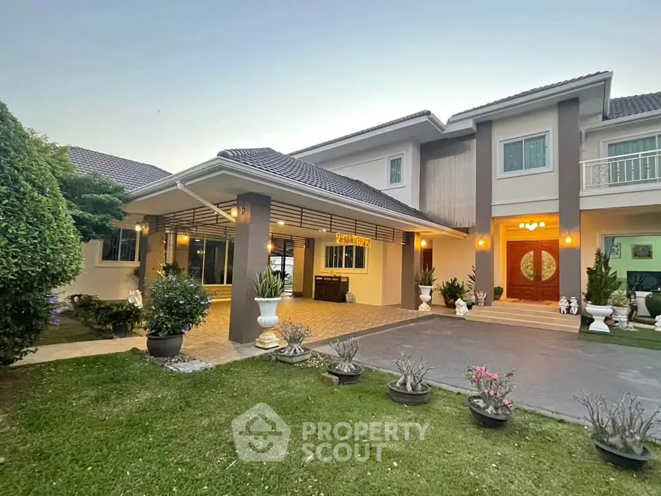Stunning two-story home with elegant entrance and lush garden, perfect for luxurious living.