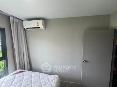 Cozy bedroom with air conditioning and natural light, perfect for relaxation.