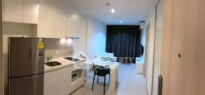 Modern open-layout kitchen and living area with sleek white cabinetry and cozy seating.