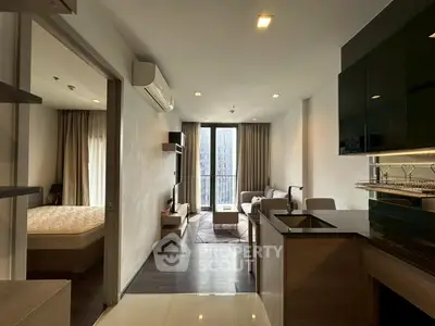 Modern open-plan living room with kitchen and balcony view in urban apartment.