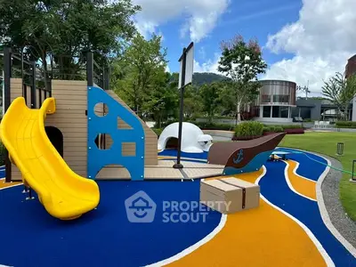 Vibrant playground with slide and ship-themed structure in modern residential area.