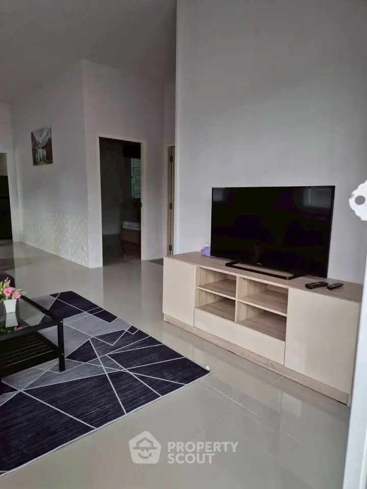 Modern living room with sleek TV stand and geometric rug design
