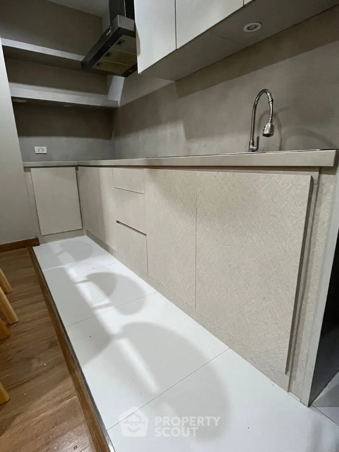 Modern kitchen with sleek cabinetry and minimalist design, featuring a built-in sink and ample storage space.