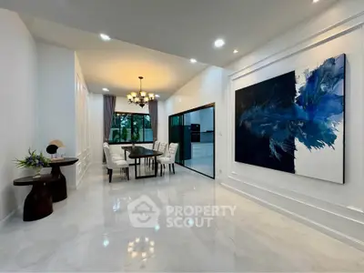 Elegant dining area with modern art and chandelier in a spacious open layout