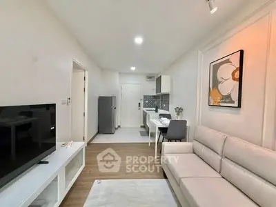 Modern living room with open kitchen, sleek decor, and cozy ambiance.