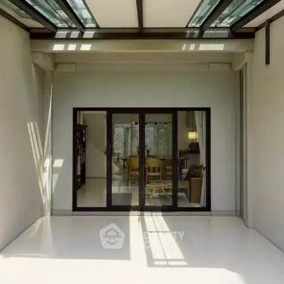 Modern home with glass doors leading to a spacious living area, featuring sleek design and ample natural light.