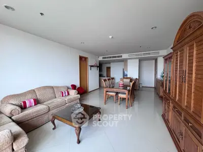Spacious living room with elegant wooden furniture and dining area in modern apartment.