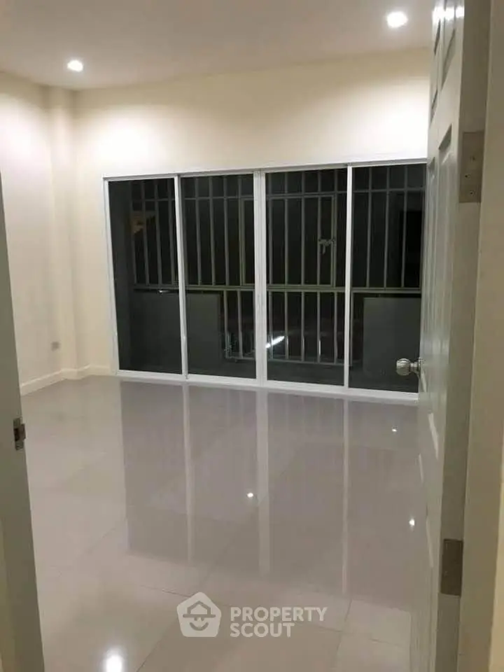 Spacious empty room with large windows and glossy tiled floor, perfect for customization.