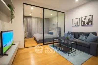 Modern living room with glass partition to bedroom, stylish decor, and cozy seating area.