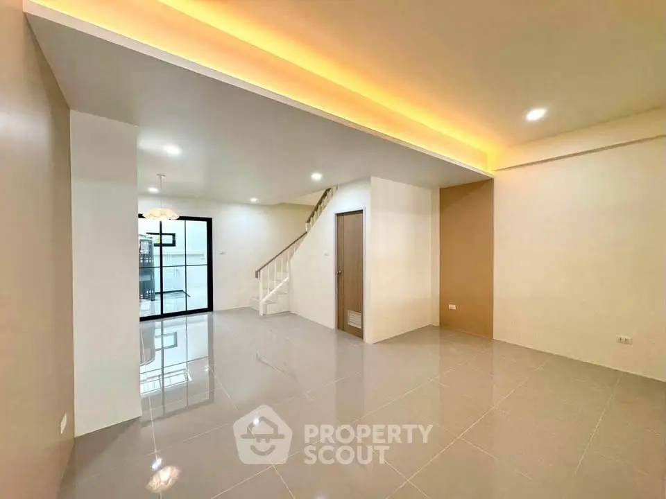 Spacious modern living room with sleek tile flooring and ambient lighting, perfect for contemporary living.
