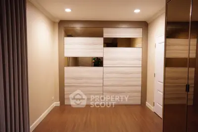 Modern bedroom with stylish wooden wardrobe and elegant lighting