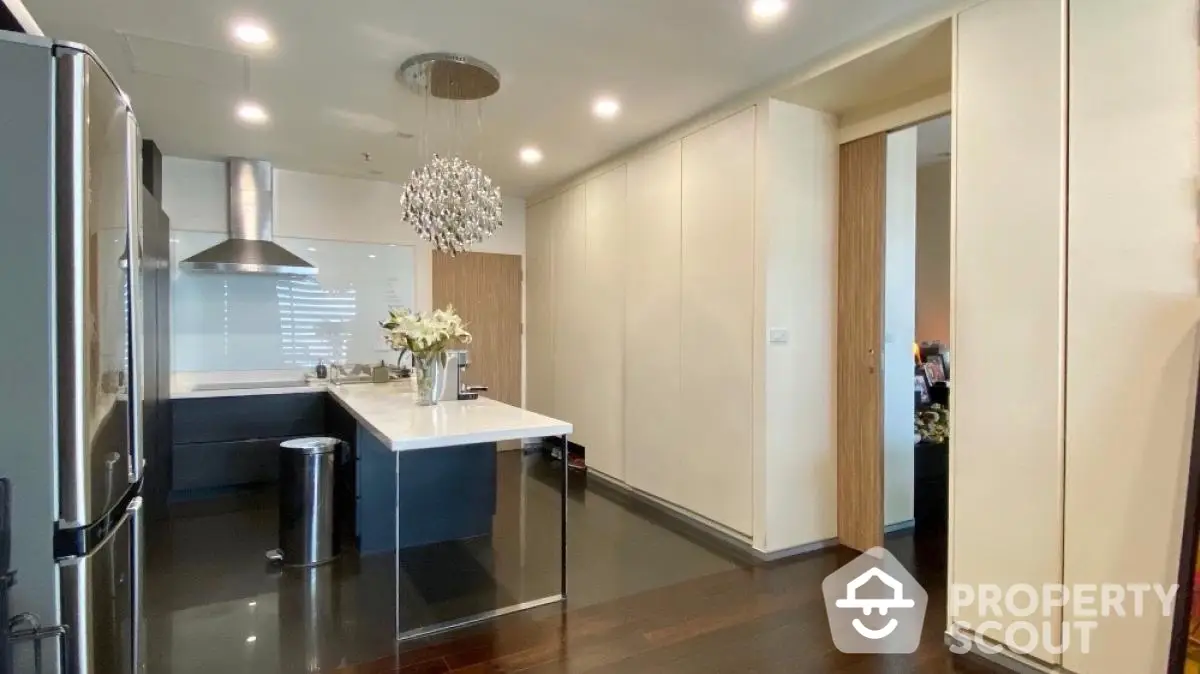 Modern kitchen with sleek design, featuring an island and contemporary lighting.