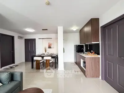 Modern open-plan living and dining area with sleek kitchen design and stylish decor.