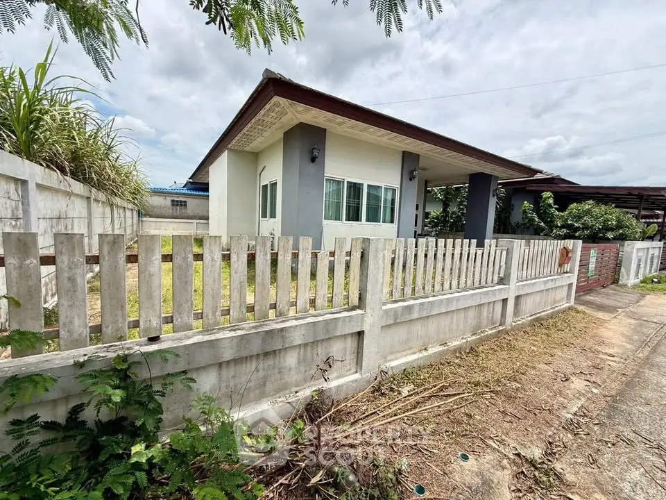 Charming single-story home with fenced yard and lush greenery, perfect for tranquil living.